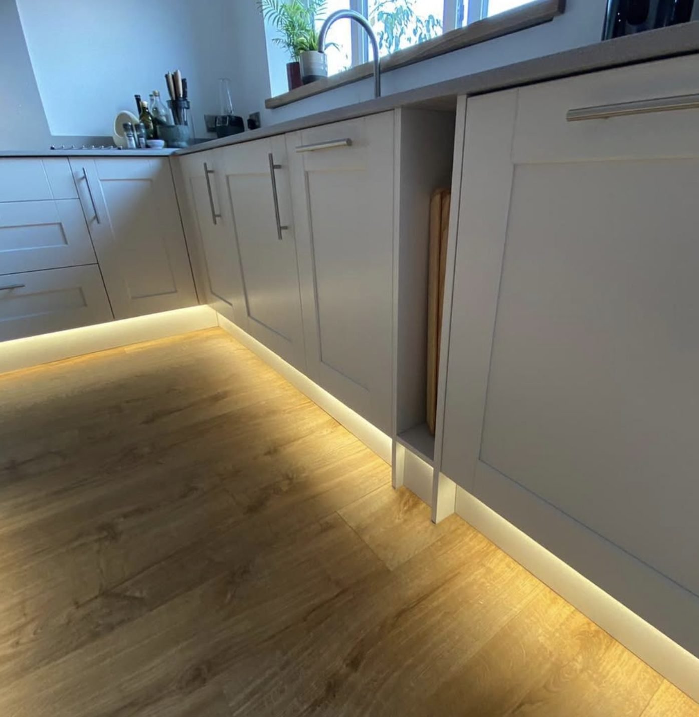 Warm LED plinth lighting in a fitted kitchen